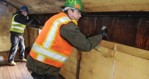 Brothers Forest, right, and Augest Endicott, principals with Northwest Deconstruction Services, remove wood paneling while deconstructing a 127-year-old house in Northeast Portland. (Sam Tenney/DJC)
