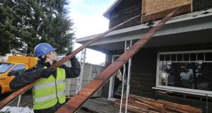Augest Endicott, co-principal of Northwest Deconstruction Specialists, removes material from a home undergoing deconstruction in Northeast Portland. (Sam Tenney/DJC)