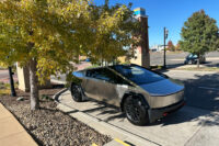 As the color of autumn paints the leaves of a tree, a Tesla Cybertuck sits in a parking space in a shopping mall Tuesday, Oct. 14, 2025, in northeast Denver. (AP Photo/David Zalubowski)