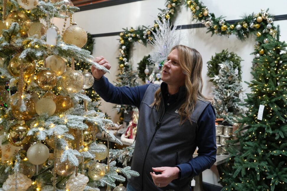 Mac Harman, founder and CEO of Balsam Hill, looks at artificial Christmas trees at the company's outlet store in Burlingame, Calif. on Dec. 10, 2025. (AP Photo/Terry Chea)