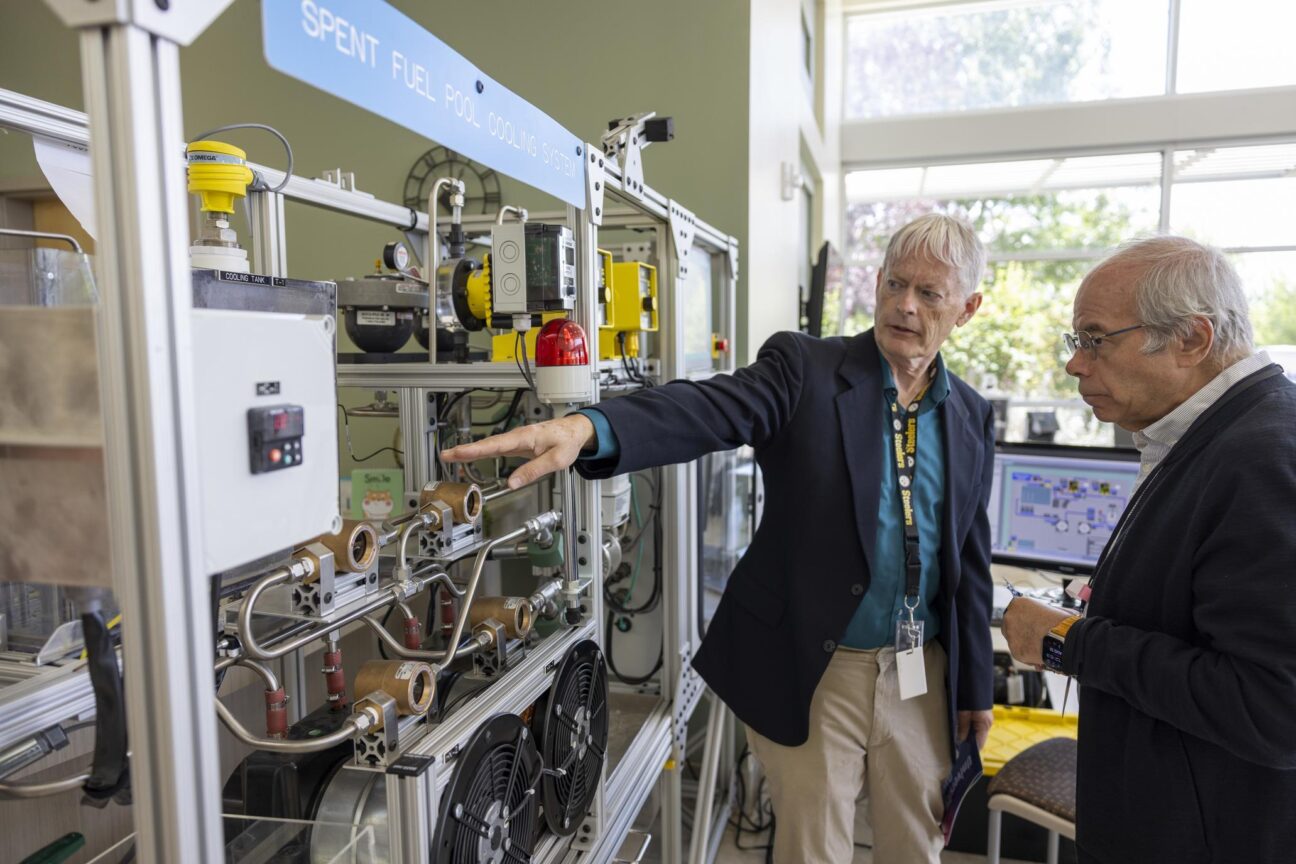 An INL nuclear cybersecurity specialist demonstrates the spent fuel pool cooling system skid and INL's University Days 2025. (PHOTO: INL)