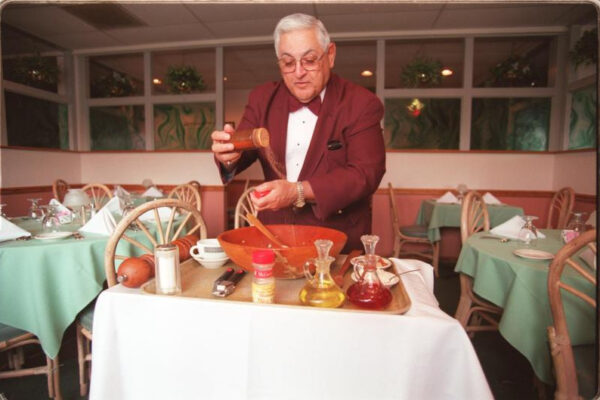 With a flick of the wrist in 1994, Vincent Mancari adds a dash of seasoning to his Caesar salad. (PHOTO: VIA REUTERS)
