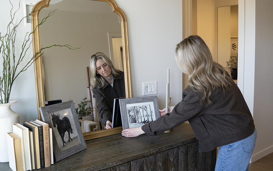 Sienna Quinlivan, lead stager and designer at Frances Joy Staging, adjusts a photo in a condominium the company staged in eastern Boise.(PHOTO: MARC LUTZ, IBR)