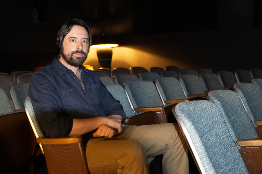 Aidan Brezonick, founder and artistic director of Idaho Film Society, sits in the 62-seat theater the organization features at its location in dowtown Boise. (PHOTO: MARC LUTZ, IBR)
