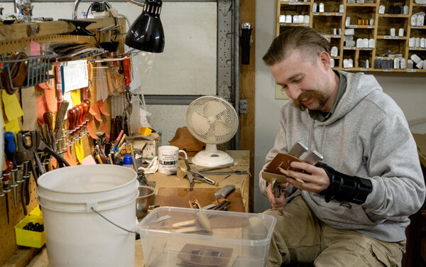 Wolfgang Snyder, a craftsman with Milt Sparks Holsters, works on a custom design at his workstation. (PHOTO: MARC LUTZ, IBR)