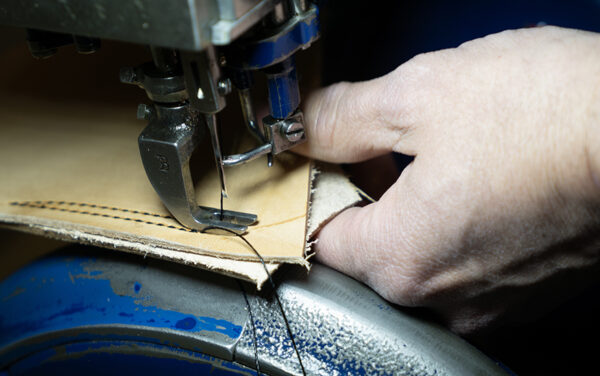 An industrial sewing machine is used to stitch together pieces of leather. (PHOTO: MARC LUTZ, IBR)