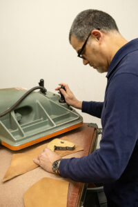 Nick Harvey uses a die cut to begin the process of creating a holster. (PHOTO: MARC LUTZ, IBR)