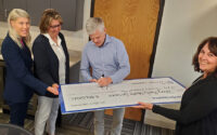 A check is being signed from PacificSource to Terry Reilly Health Services. (PHOTO: TERRY REILLY)