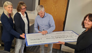 A check is being signed from PacificSource to Terry Reilly Health Services. (PHOTO: TERRY REILLY)