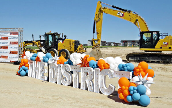 Signage, balloons and heavy equipment reminded attendees about the purpose of the groundbreaking event. (PHOTO: STEVE LOMBARD, IBR)