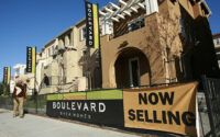 A pedestrian walks past a sign advertising new condominium homes for sale in South San Francisco on Dec. 22, 2009. (PHOTO: REUTERS/ROBERT GALBRAITH/FILE)
