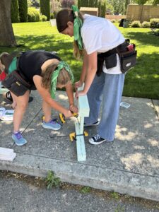Two of the attendees at Let's Build Idaho's girls camp help each other on one of the projects they build over the period of one week. (PHOTO: LET'S BUILD IDAHO)
