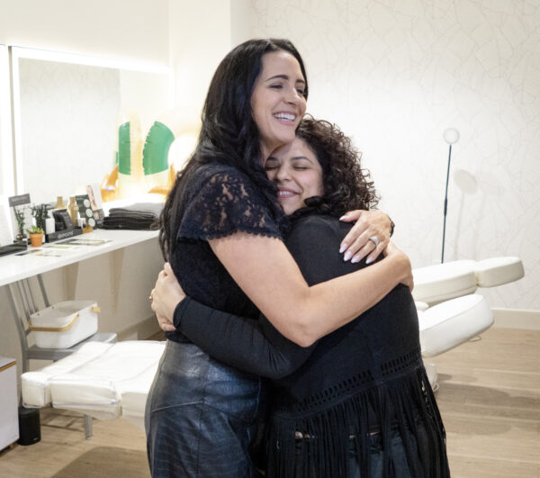 Shelby Bills hugs Gabby Marcantonio, one of more than 30 employees at Graeber & Company. (PHOTO: MARC LUTZ, IBR)