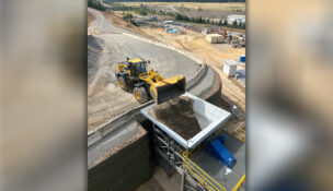 A backhoe loads ore into a crusher hopper Bunker Hill Corp.'s Kellogg mining operation. (PHOTO: BUNKER HILL MINING)